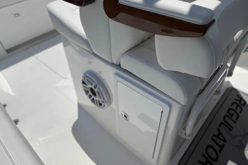 Slide: The Image of 2026 Regulator 31 boat interior with white seating, speaker, and storage compartment. - 43