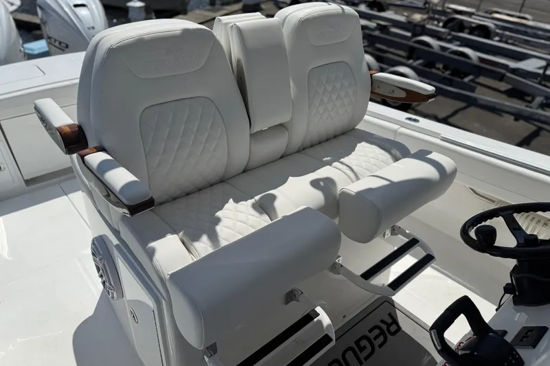 Slide: The Image of Luxurious seating on 2026 Regulator 31 boat, featuring white quilted upholstery and armrests. - 46