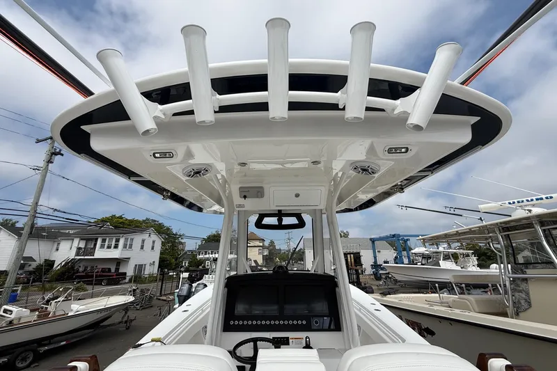 Slide: The Image of 2026 Regulator 31 boat helm with rod holders and electronics, docked in a marina. - 5