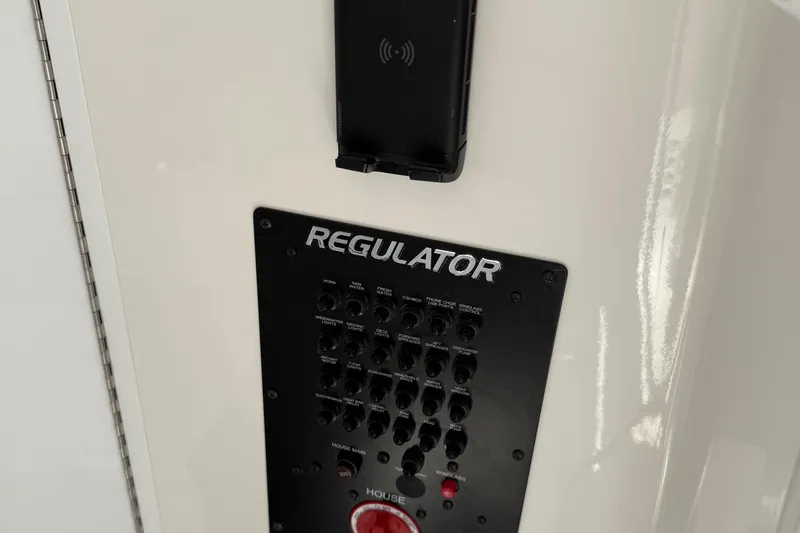 Slide: The Image of Control panel of 2026 Regulator 31 boat with switches and wireless charging pad. - 52