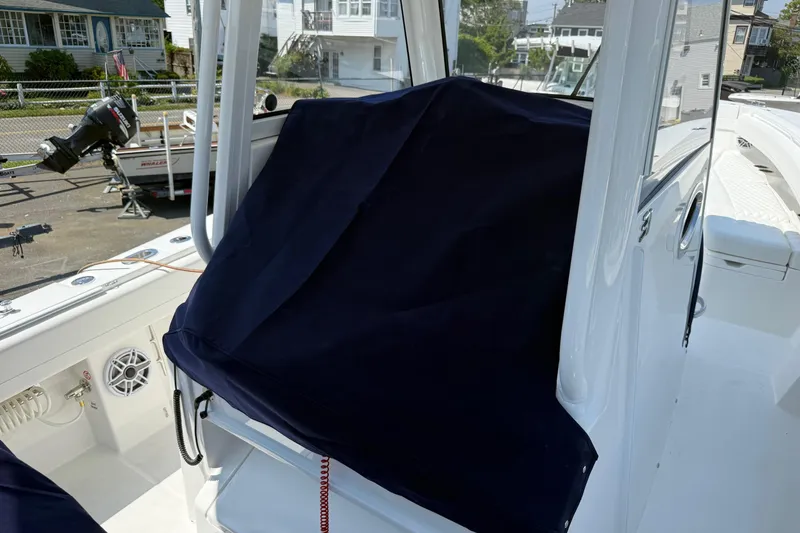 Slide: The Image of 2026 Regulator 31 boat interior with covered console, docked near residential area. - 57