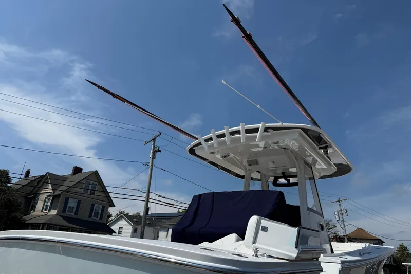 Slide: The Image of 2026 Regulator 31 boat with T-top and outriggers under clear blue sky. - 60