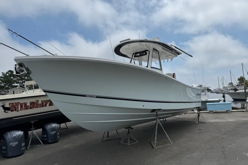 Slide: The Image of 2026 Regulator 31 boat on stands at a marina, under a cloudy sky. - 9
