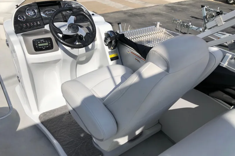Slide: The Image of 2015 Avalon Catalina Entertainer boat interior with steering wheel and captain's chair. - 11