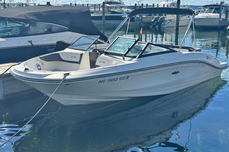 The Image of 2018 Sea Ray SPX 210 boat docked in a marina, reflecting on calm water. - 1