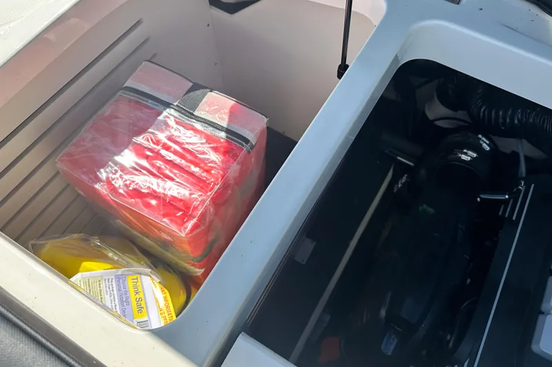 Slide: The Image of Storage compartment of 2018 Sea Ray SPX 210 boat with safety equipment. - 23