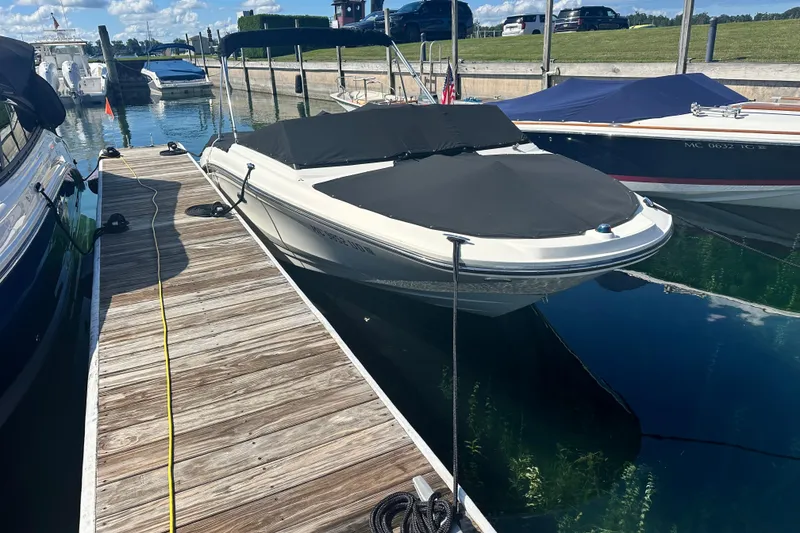 Slide: The Image of 2018 Sea Ray SPX 210 boat docked with cover, sunny day, clear water. - 5