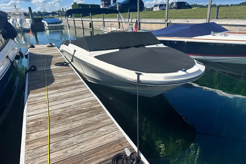 Slide: The Image of 2018 Sea Ray SPX 210 boat docked with cover, sunny marina setting. - 6