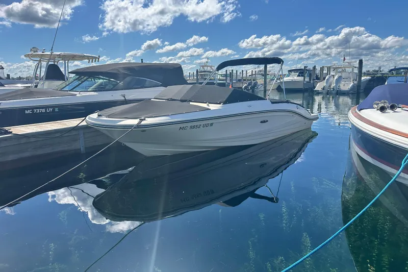 Slide: The Image of 2018 Sea Ray SPX 210 boat docked in a sunny marina, reflecting on calm water. - 8