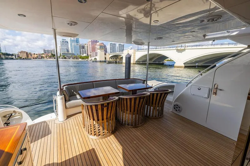 Slide: The Image of 2013 Hatteras 80 Motor Yacht deck with elegant seating and waterfront view. - 16