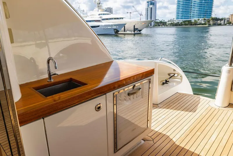 Slide: The Image of 2013 Hatteras 80 Motor Yacht deck with sink and cabinetry, overlooking marina. - 17