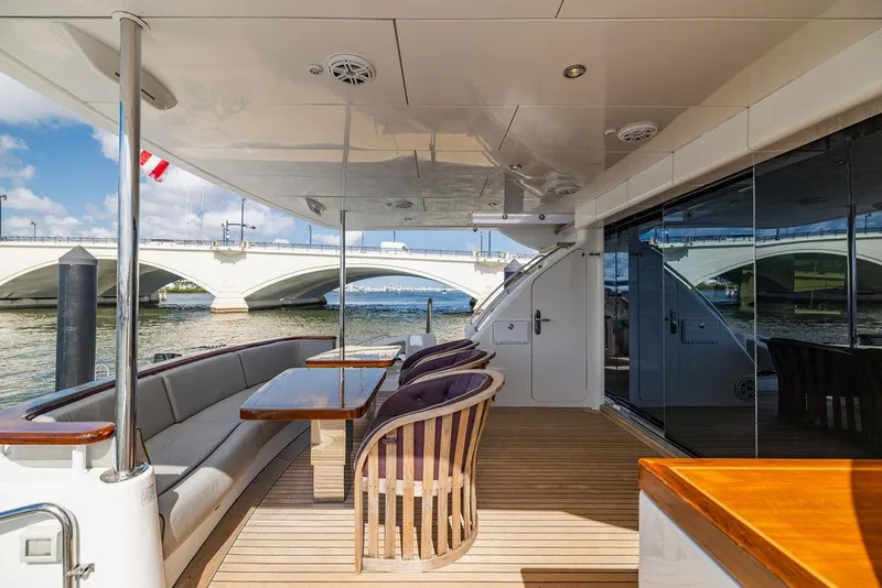 Slide: The Image of 2013 Hatteras 80 Motor Yacht deck with seating, tables, and bridge view. - 18
