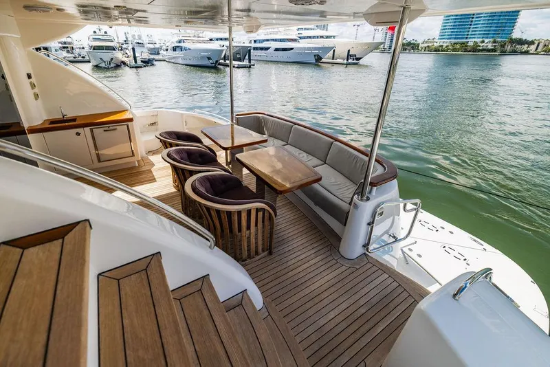 Slide: The Image of Luxurious 2013 Hatteras 80 Motor Yacht deck with elegant seating and waterfront view. - 26