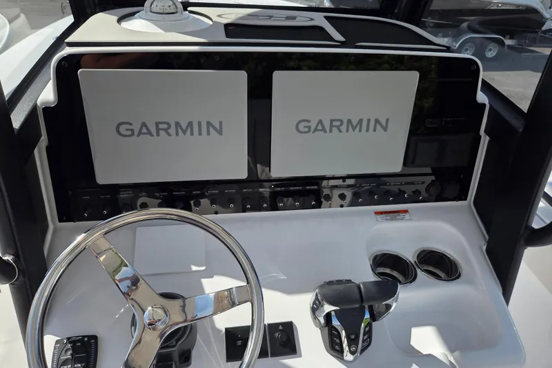 Slide: The Image of 2026 Sea Hunt Gamefish 25 dashboard with dual Garmin displays and steering wheel. - 10