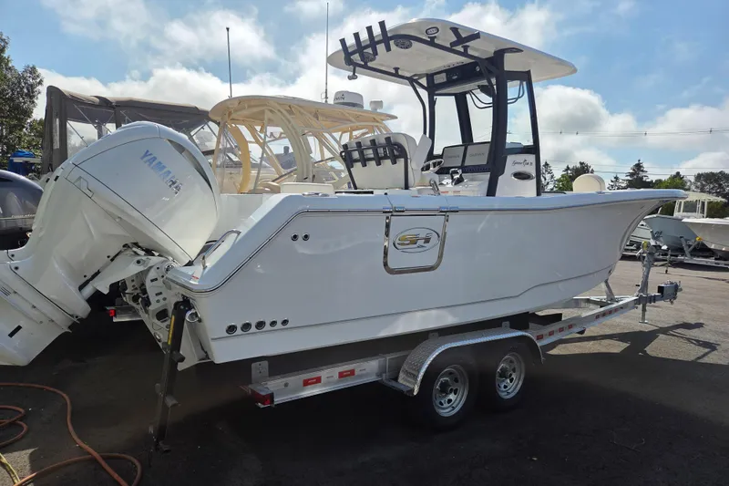 Slide: The Image of 2026 Sea Hunt Gamefish 25 boat on trailer with Yamaha engine, parked outdoors. - 3