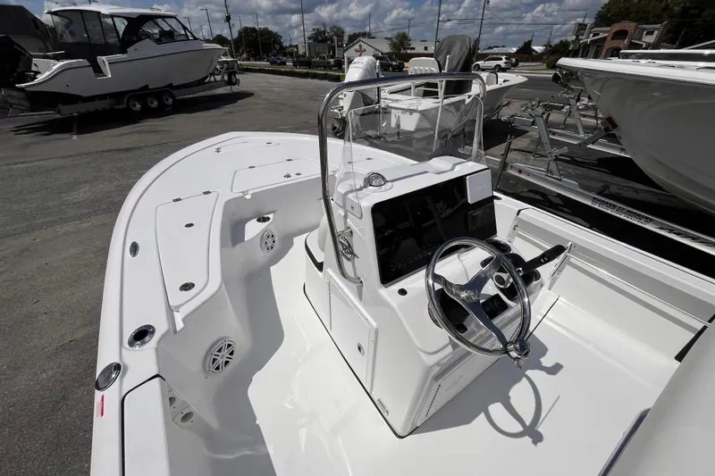 Slide: The Image of 2026 Tidewater 1910 Bay Max boat with sleek console and steering wheel, parked outdoors. - 11