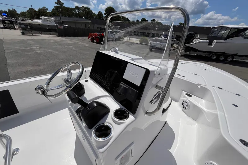 Slide: The Image of 2026 Tidewater 1910 Bay Max boat console with steering wheel and controls, parked outdoors. - 7