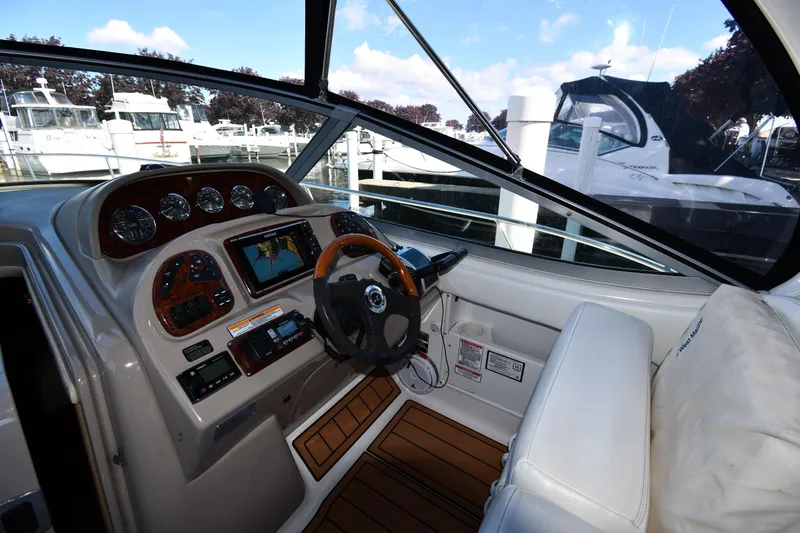 Slide: The Image of Interior cockpit of 2005 Sea Ray 300 Sundancer with navigation controls and steering wheel. - 10