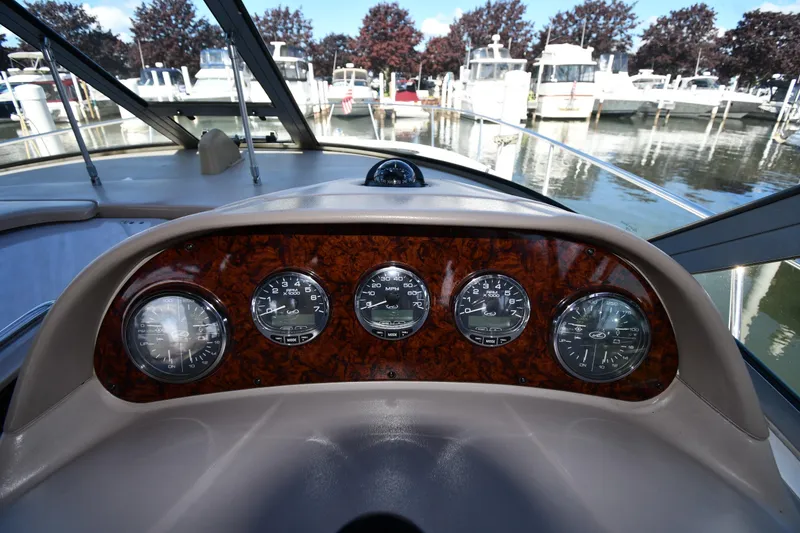 Slide: The Image of Dashboard of a 2005 Sea Ray 300 Sundancer boat with gauges and marina view. - 11