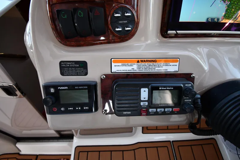 Slide: The Image of Control panel of a 2005 Sea Ray 300 Sundancer boat with radio and warning labels. - 13