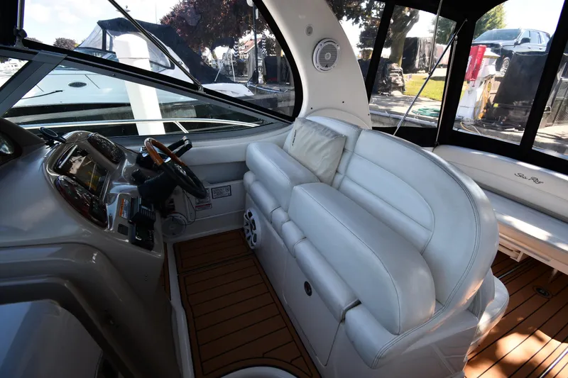 Slide: The Image of 2005 Sea Ray 300 Sundancer interior with white leather seating and wooden flooring. - 15