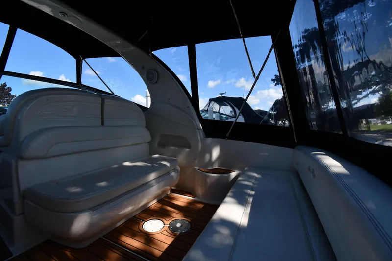 Slide: The Image of Interior of 2005 Sea Ray 300 Sundancer boat with cushioned seating and wood flooring. - 16