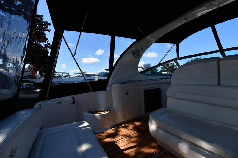 Slide: The Image of Interior of 2005 Sea Ray 300 Sundancer boat with seating and windows, under a clear blue sky. - 17