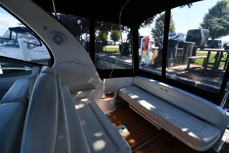 Slide: The Image of Interior of 2005 Sea Ray 300 Sundancer boat with white seating and wood flooring. - 19