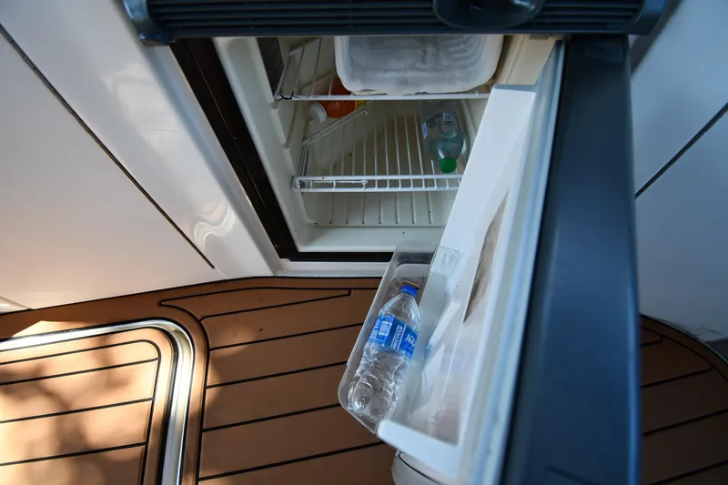 Slide: The Image of Open mini fridge on 2005 Sea Ray 300 Sundancer boat with water bottles inside. - 21