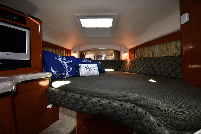 Slide: The Image of Interior cabin of 2005 Sea Ray 300 Sundancer with cozy bedding and nautical decor. - 25