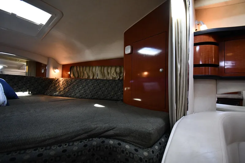 Slide: The Image of Interior cabin of 2005 Sea Ray 300 Sundancer with cozy bed and wooden cabinetry. - 26