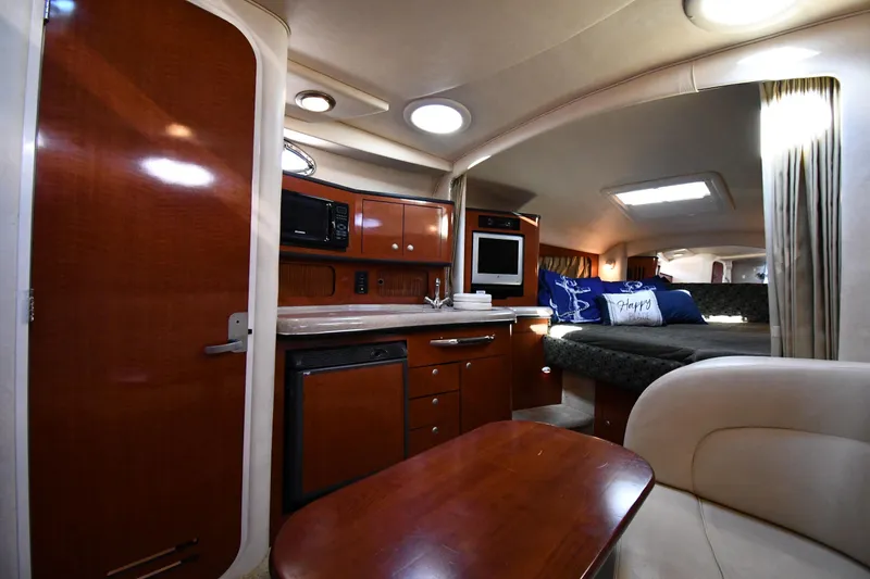 Slide: The Image of Interior of 2005 Sea Ray 300 Sundancer yacht with kitchenette and cozy seating area. - 31