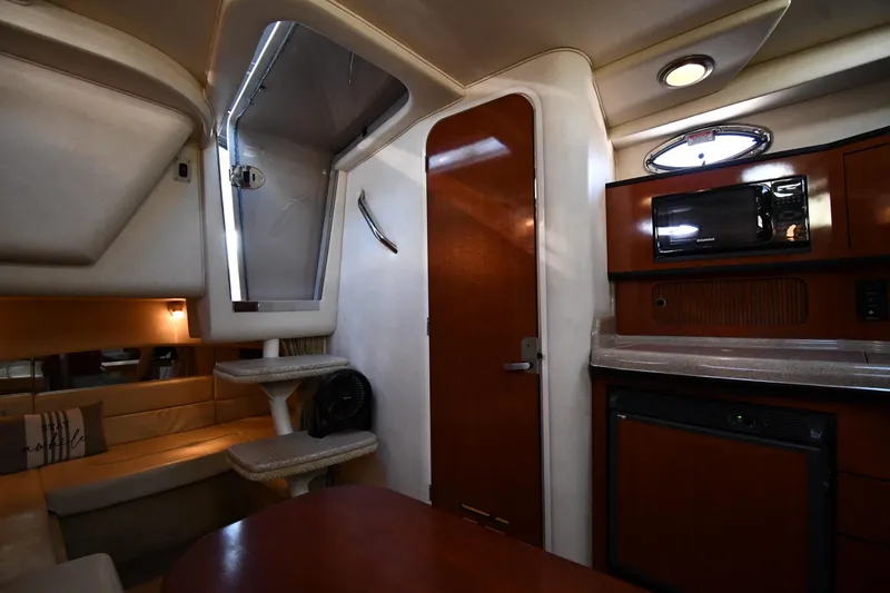 Slide: The Image of Interior of 2005 Sea Ray 300 Sundancer yacht with kitchenette and seating area. - 32