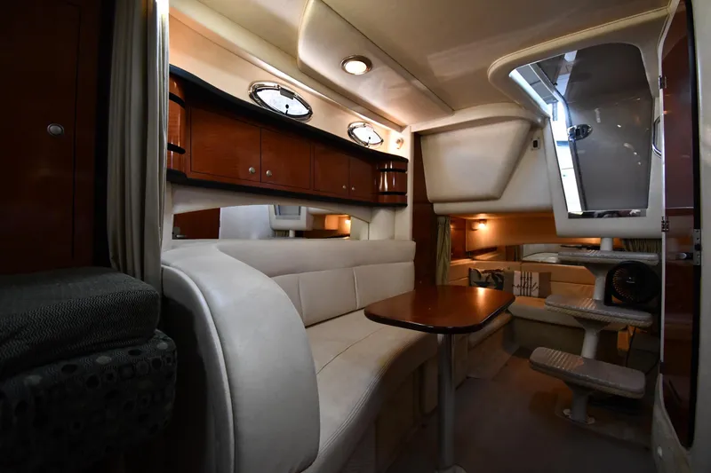 Slide: The Image of Interior of 2005 Sea Ray 300 Sundancer yacht, featuring elegant seating and wooden cabinetry. - 33