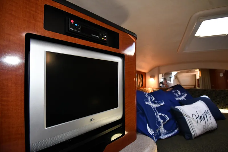Slide: The Image of 2005 Sea Ray 300 Sundancer cabin with TV and nautical-themed pillows. - 34