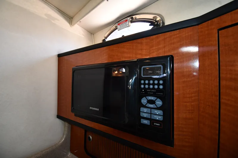 Slide: The Image of Microwave in 2005 Sea Ray 300 Sundancer boat interior, featuring wood paneling. - 37