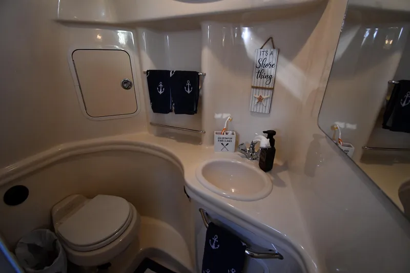 Slide: The Image of 2005 Sea Ray 300 Sundancer bathroom with nautical decor and compact design. - 40