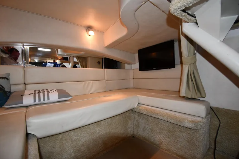 Slide: The Image of Interior of 2005 Sea Ray 300 Sundancer with beige seating and mounted TV. - 44