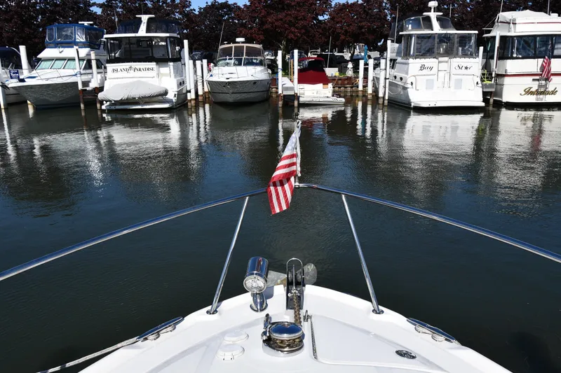 Slide: The Image of Bow view of a 2005 Sea Ray 300 Sundancer docked among other boats in a marina. - 5
