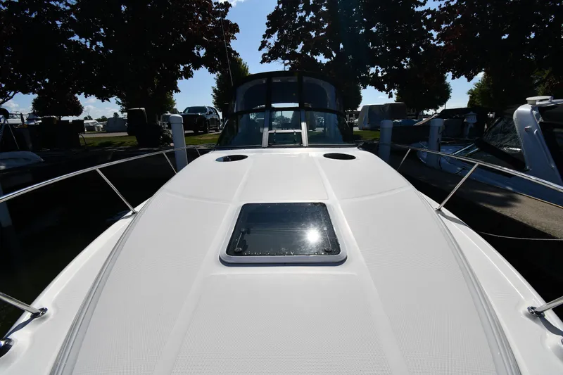 Slide: The Image of 2005 Sea Ray 300 Sundancer boat deck with hatch, docked under trees. - 6