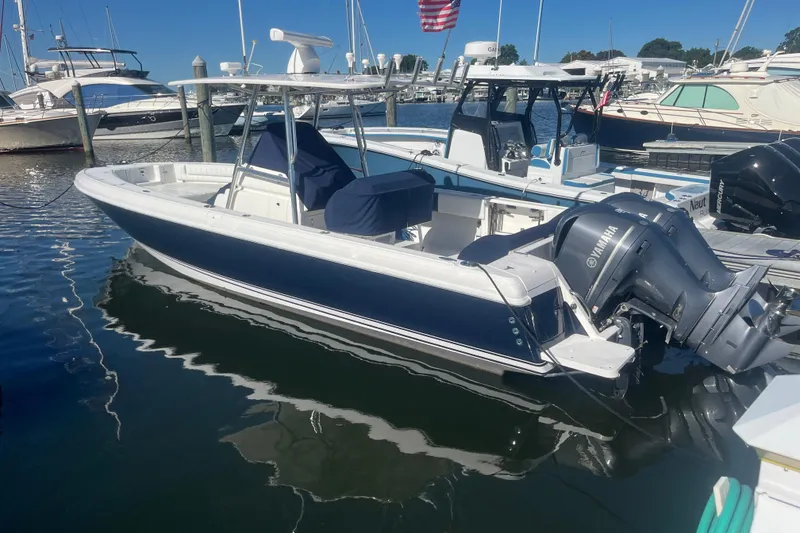 Slide: The Image of 2004 Intrepid 323 boat docked, featuring Yamaha outboard engines, in a marina setting. - 0