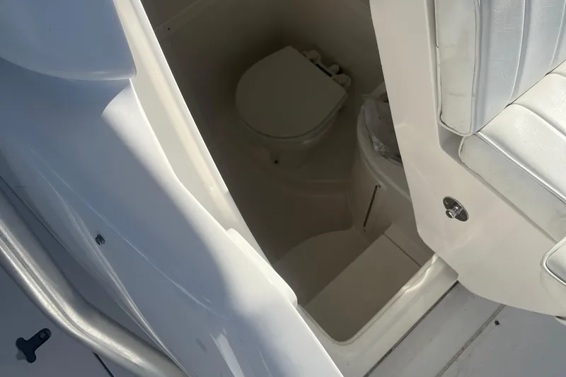 Slide: The Image of 2004 Intrepid 323 boat interior with compact bathroom and seating area. - 11