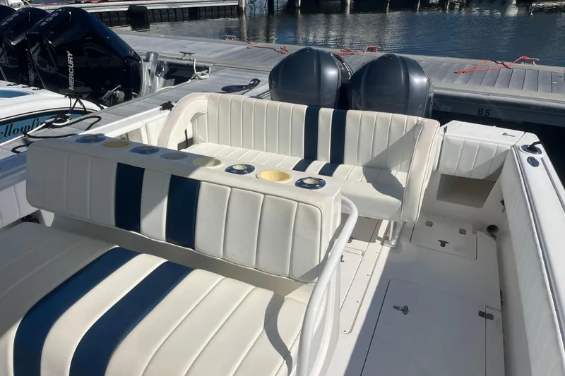 Slide: The Image of 2004 Intrepid 323 boat interior with striped seating and dual outboard motors at dock. - 12