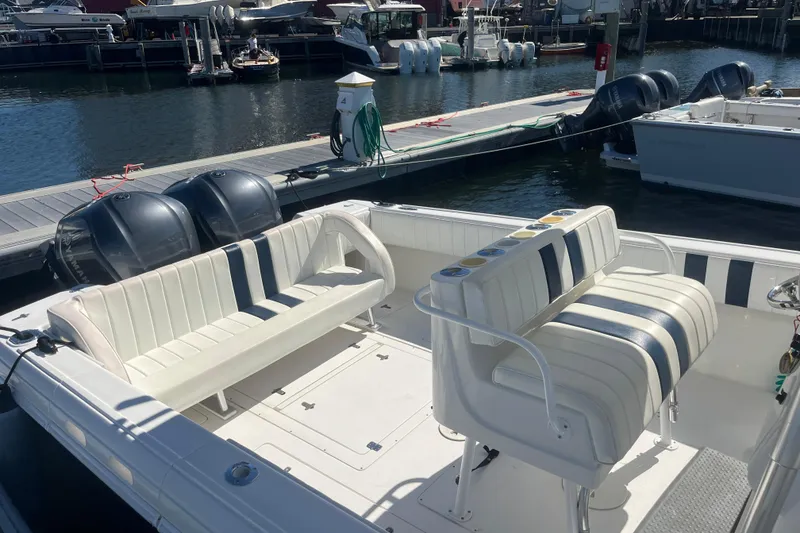 Slide: The Image of 2004 Intrepid 323 boat interior with white seating, docked at marina. - 13