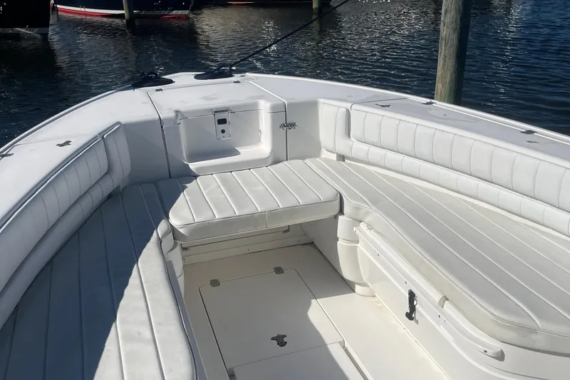 Slide: The Image of 2004 Intrepid 323 boat with white cushioned seating, docked on calm water. - 4