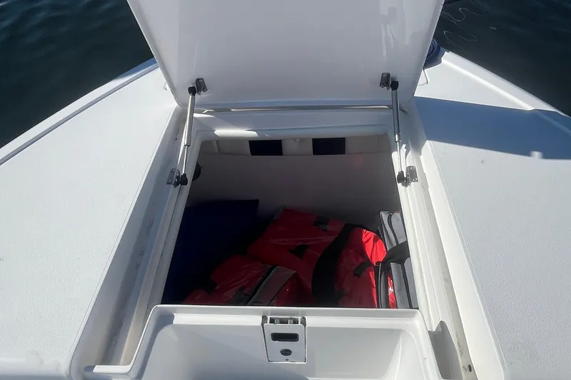 Slide: The Image of Open storage compartment on 2004 Intrepid 323 boat, containing red life jackets. - 7