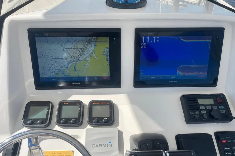 Slide: The Image of 2004 Intrepid 323 boat dashboard with Garmin navigation and control systems. - 9