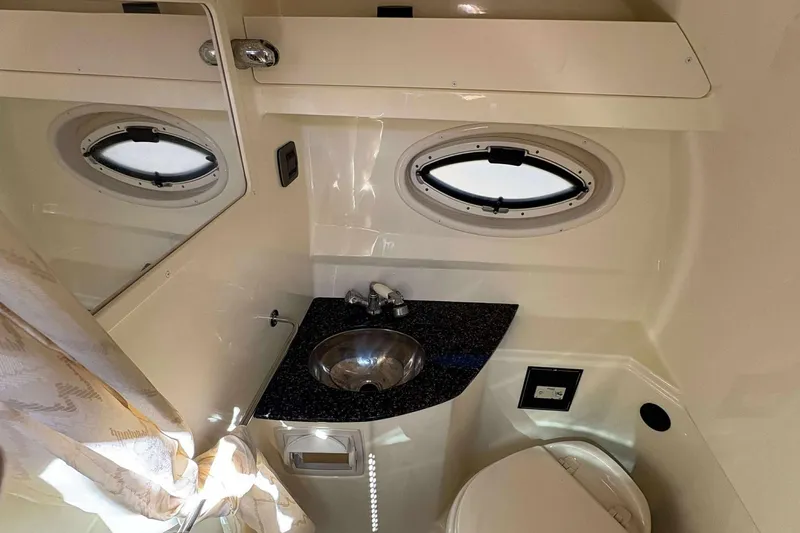 Slide: The Image of Interior of 2013 Monterey 260 SCR Sport Cruiser bathroom with sink and porthole window. - 10