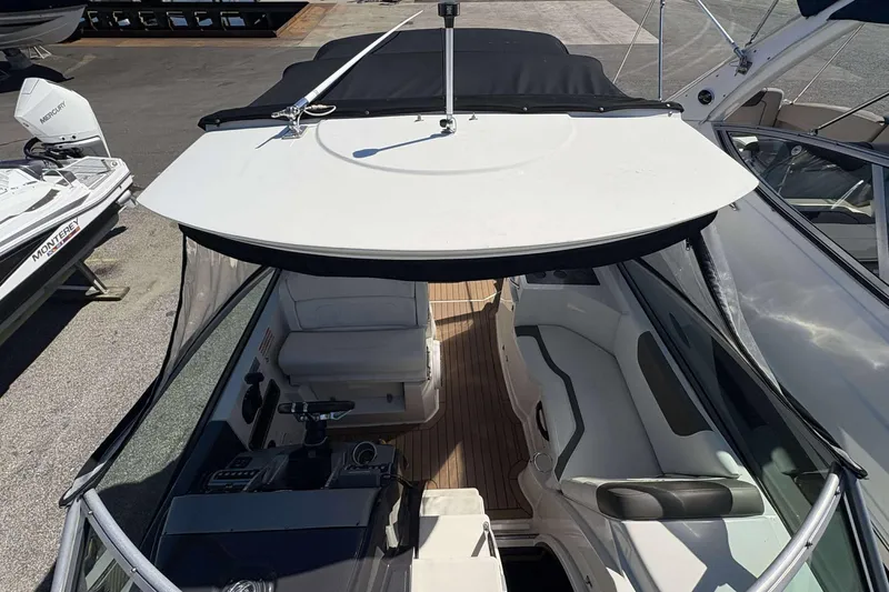 Slide: The Image of 2013 Monterey 260 SCR Sport Cruiser with black canopy and spacious seating area. - 16