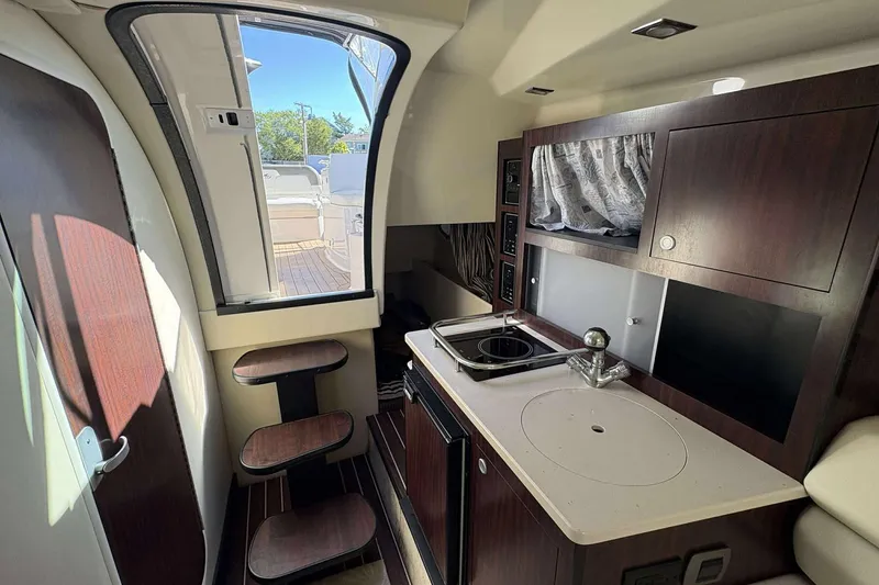 Slide: The Image of Interior of 2013 Monterey 260 SCR Sport Cruiser with kitchenette and stairs to deck. - 8